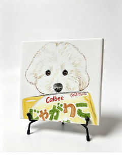 Custom portrait tile featuring a fluffy white dog holding a Calbee snack bag on a black metal tabletop easel