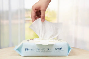 Hand pulling a wet wipe from a FurBaby branded wet wipes pack.
