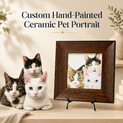 Three cats beside a custom hand-painted ceramic pet portrait displayed in a rustic dark wood frame on a tabletop easel
