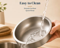 Stainless steel pet bowl being rinsed under running water, showing its smooth and easy-to-clean surface