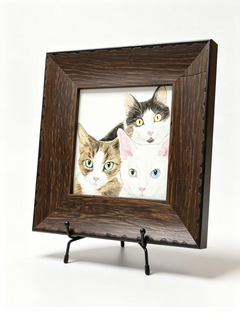 Rustic dark wood pet memorial frame displaying a portrait of three cats on a black metal tabletop easel